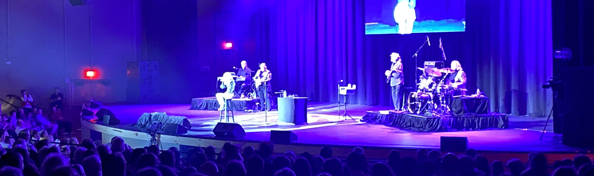 signer on stage in chair washed out by the lights Columbia